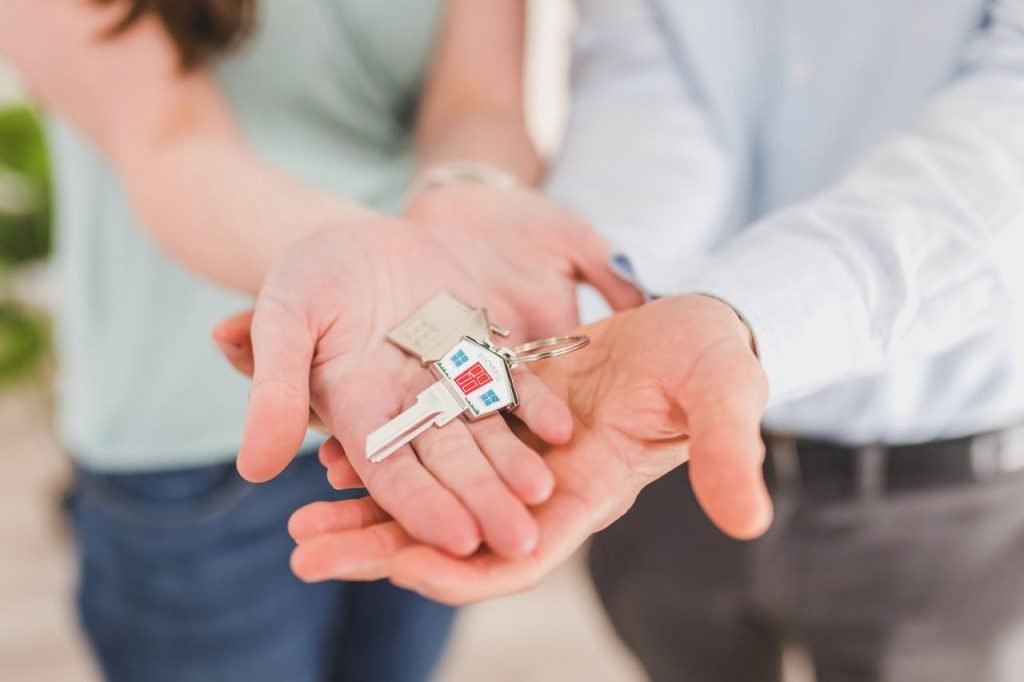 Close-up of a couple holding keys, symbolizing homeownership and investment.