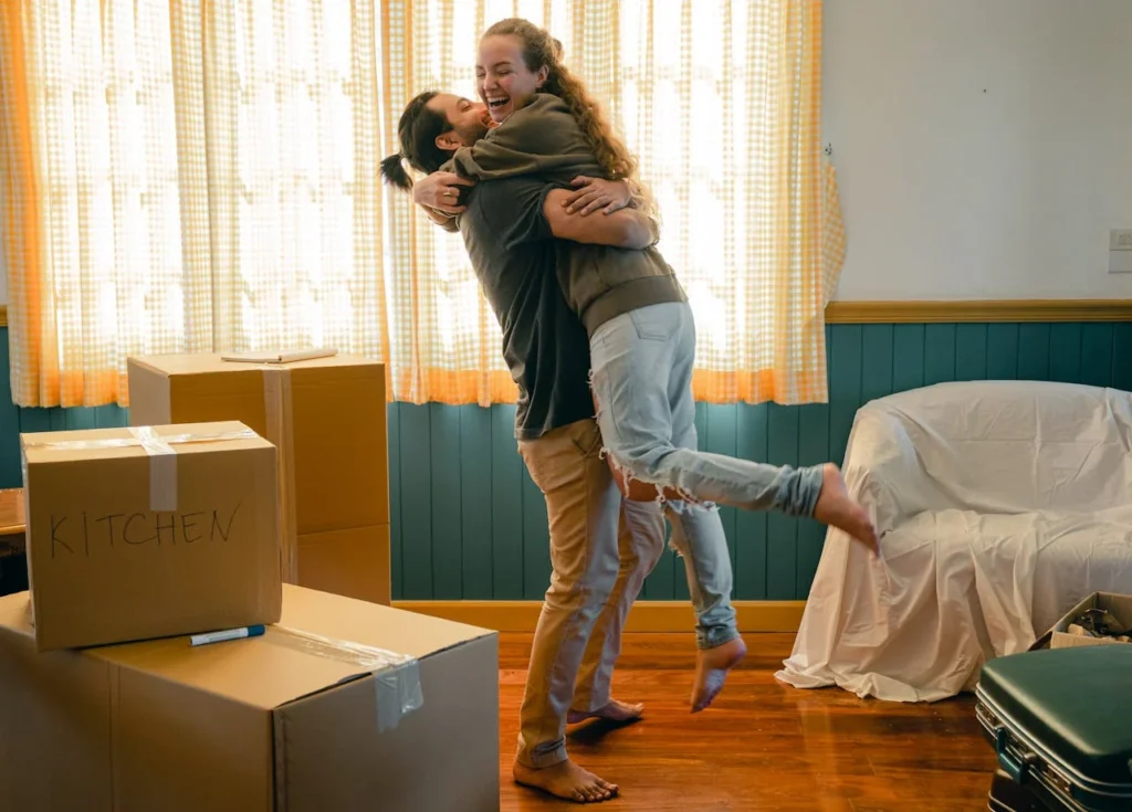 cheerful couple hugging and unpacking carton boxes 4246234